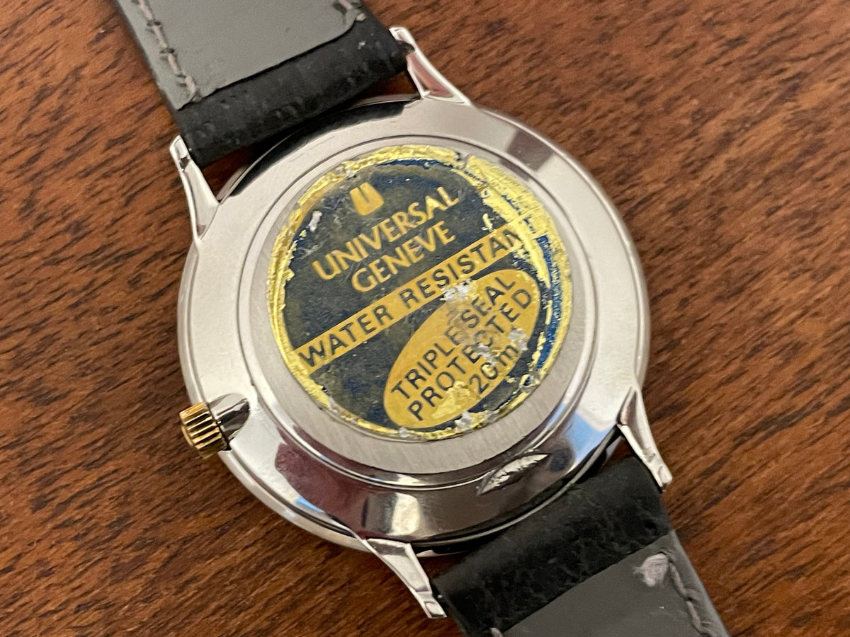 (1980s) Universal Genève 6-566 dress watch - silver case w/ gold beaded bezel - grey sunburst dial (NOS)