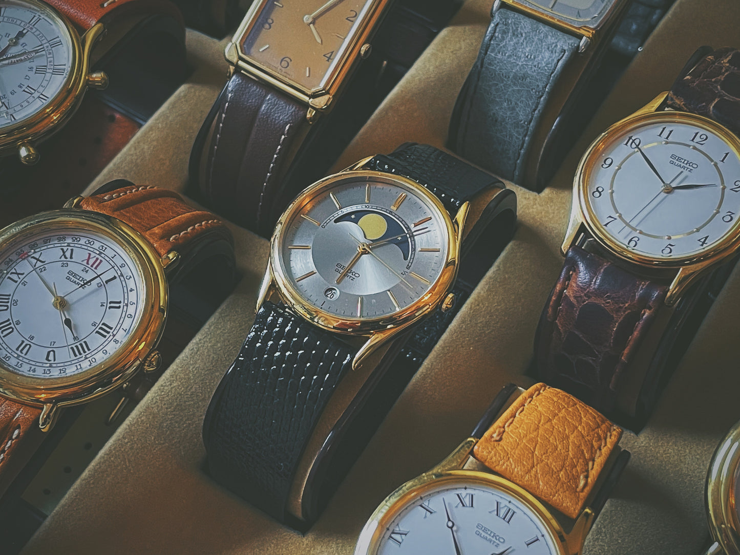 Seiko 7434-7000 dress watch with moon phase in showcase next to other Seiko dress watches