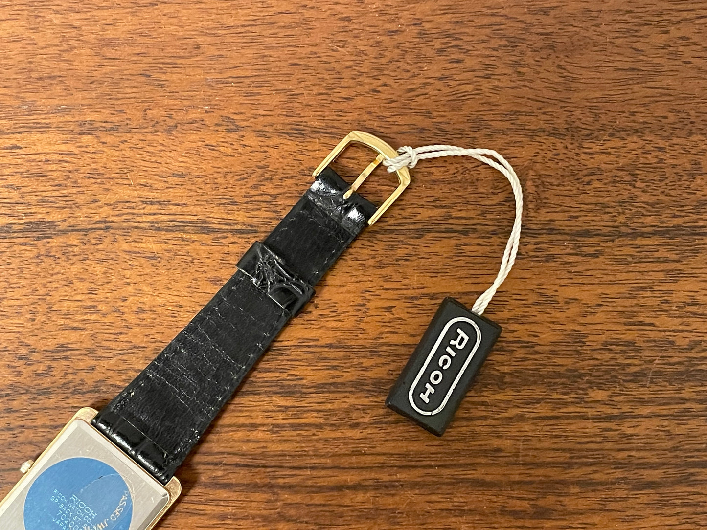 (1977) Ricoh 702009 quartz "Tank" dress watch - black dial w/ gold markers (NOS)