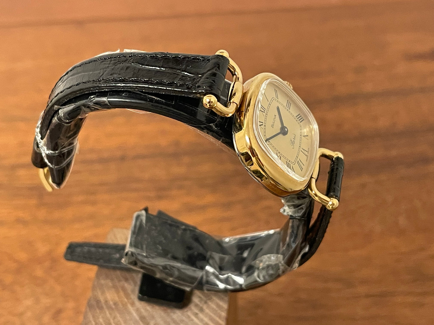 (1980s/1990s) Bulova Paris dress watch - cushion case - gold dial w/ black Roman numerals - small size (NOS)