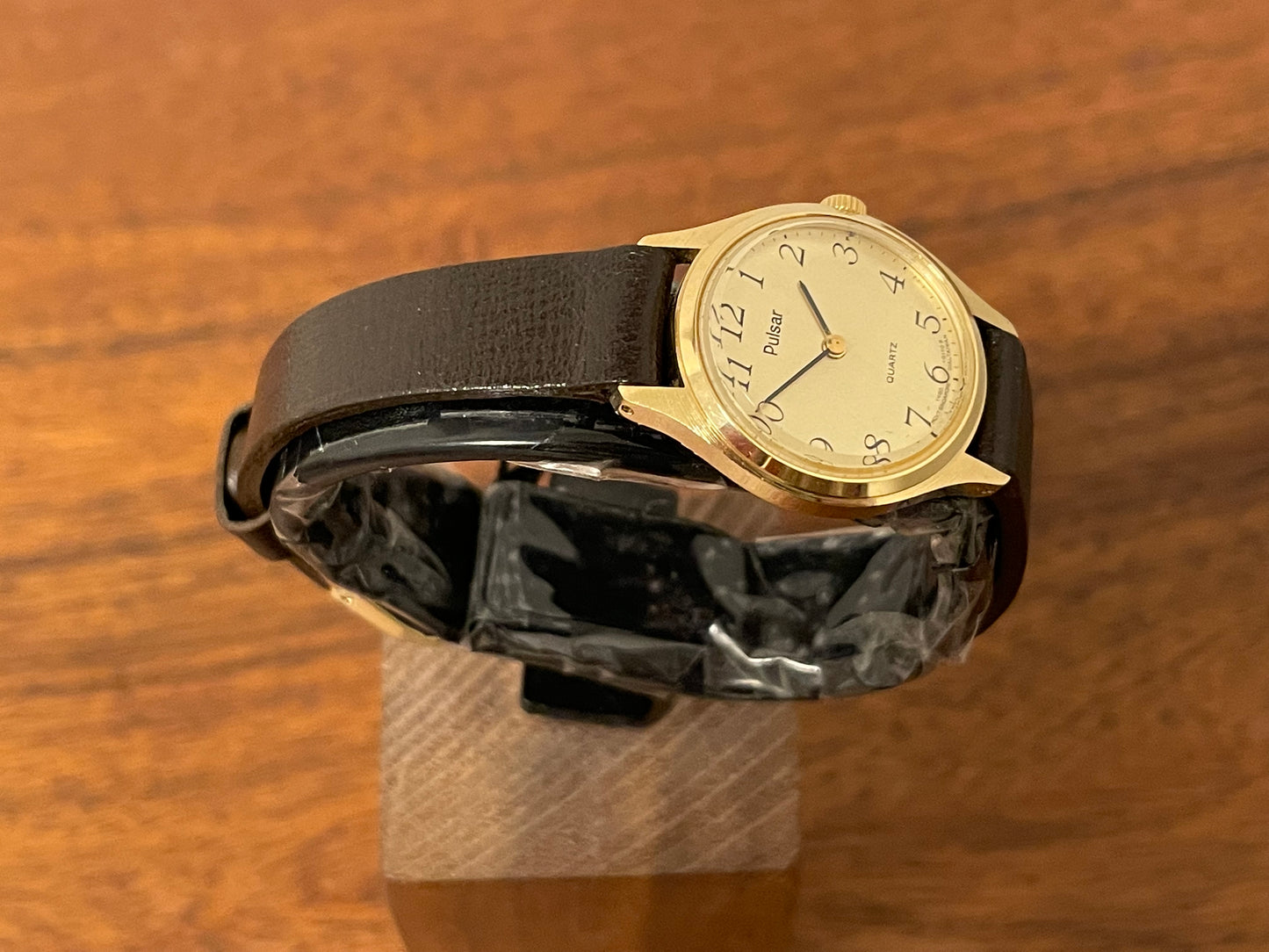 (1990) Pulsar Y480-0060 dress watch - gold colored case - champagne dial w/ black Arabic numerals - small size (NOS)