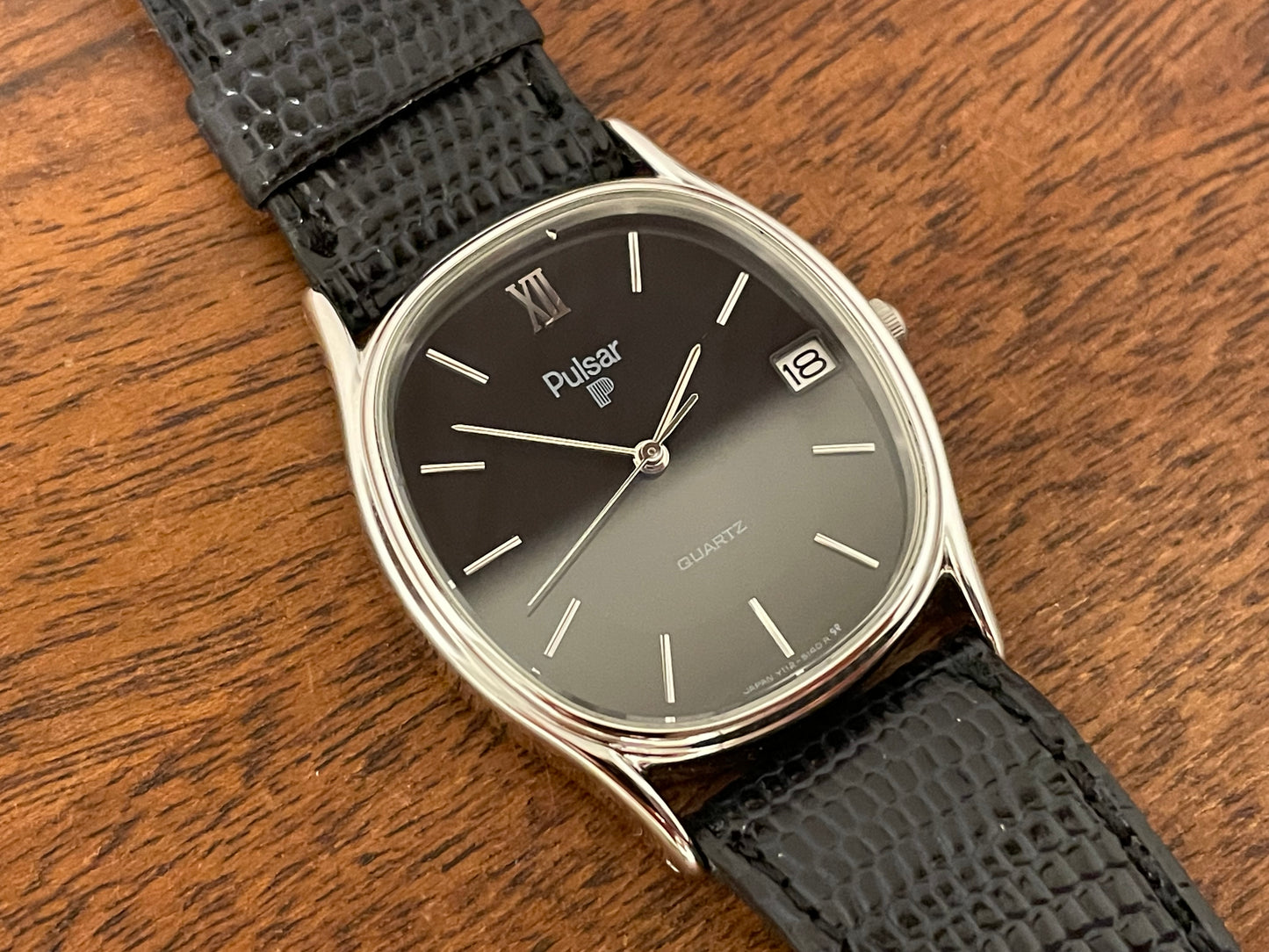 (1982) Pulsar Y112-5099 "Ellipse" dress watch - silver case - black dial w/ silver stick markers (NOS)