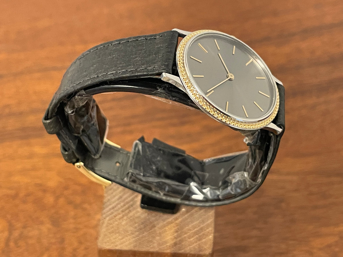 (1980s) Universal Genève 6-566 dress watch - silver case w/ gold beaded bezel - grey sunburst dial (NOS)