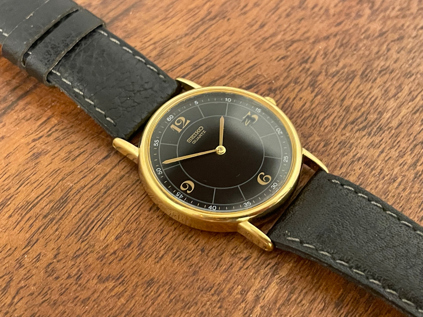 (2000) Seiko 5Y39-7010 dress watch - gold colored case - black dial w/ flat gold Arabic numerals (NOS)