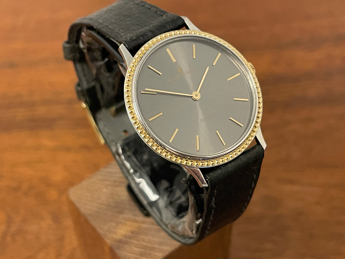(1980s) Universal Genève 6-566 dress watch - silver case w/ gold beaded bezel - grey sunburst dial (NOS)