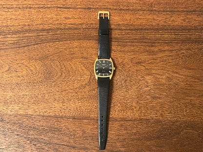 (1970s) Tissot Stylist dress watch - gold case - black dial w/ gold Roman numerals (NOS)