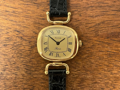(1980s/1990s) Bulova Paris dress watch - cushion case - gold dial w/ black Roman numerals - small size (NOS)