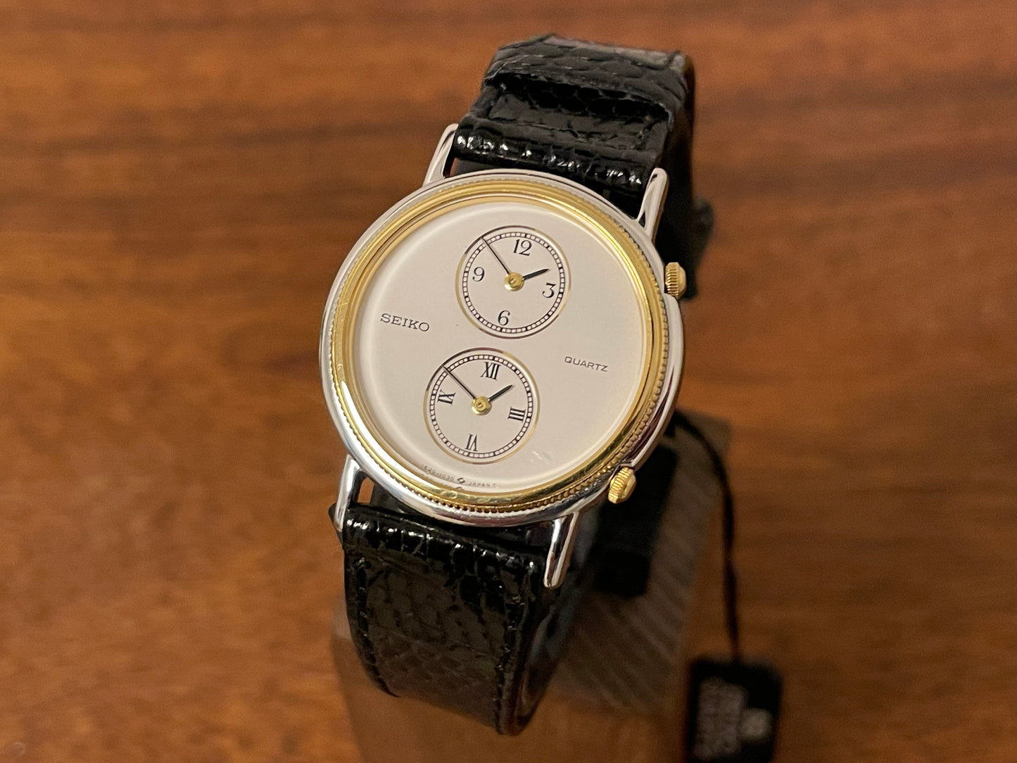 front side (1985) Seiko 1E20-0160 dual time dress watch - round case - white dial w/ 2 subdials  (NOS)