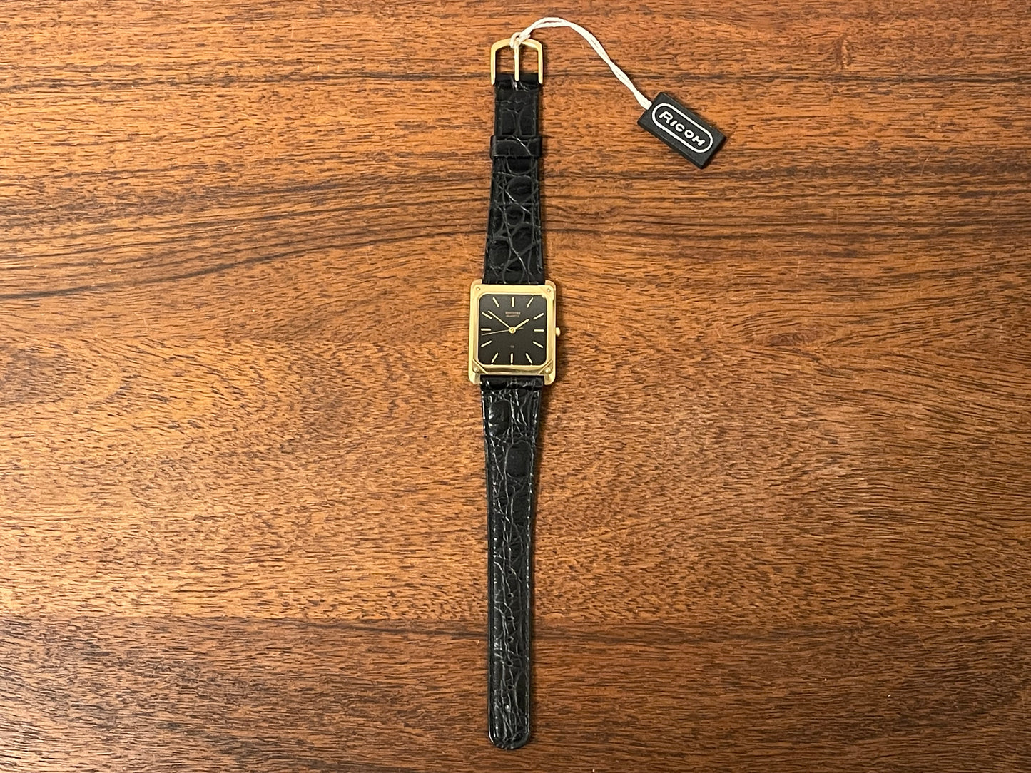 (1977) Ricoh 702009 quartz "Tank" dress watch - black dial w/ gold markers (NOS)