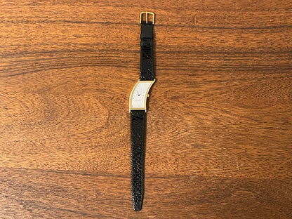 (1988) Cleto Munari "Parentesi" by Hans Hollein - asymmetrical 18K gold electroplated case - white dial w/ Roman numerals  (NOS + full set)