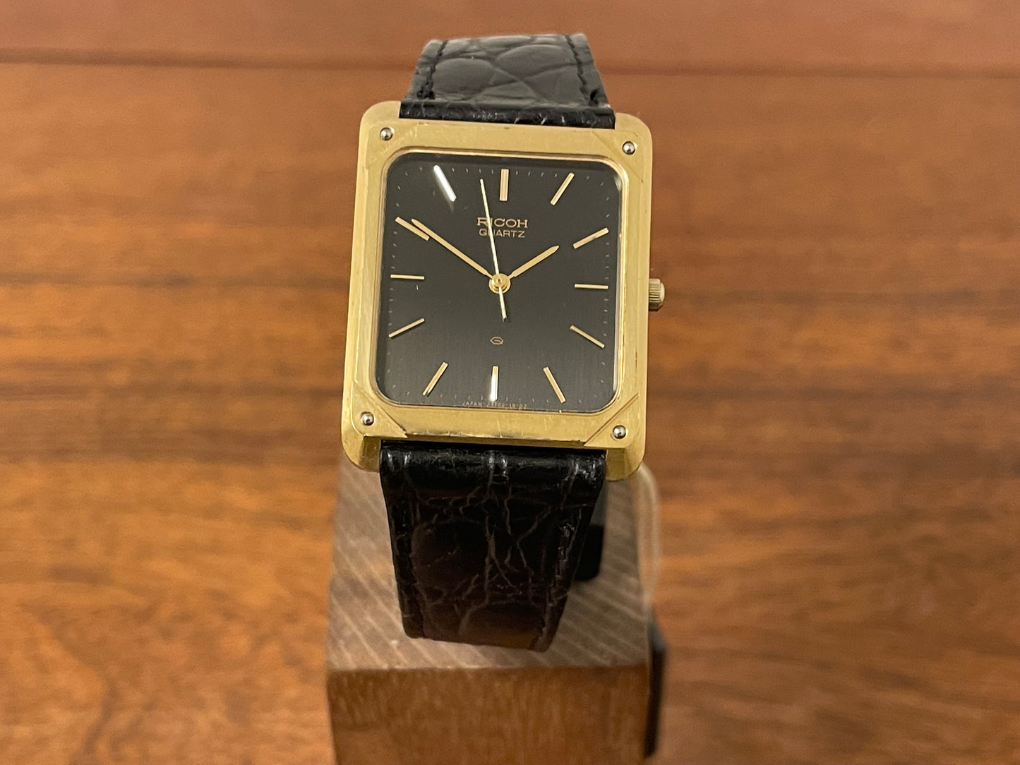 (1977) Ricoh 702009 quartz "Tank" dress watch - black dial w/ gold markers (NOS)