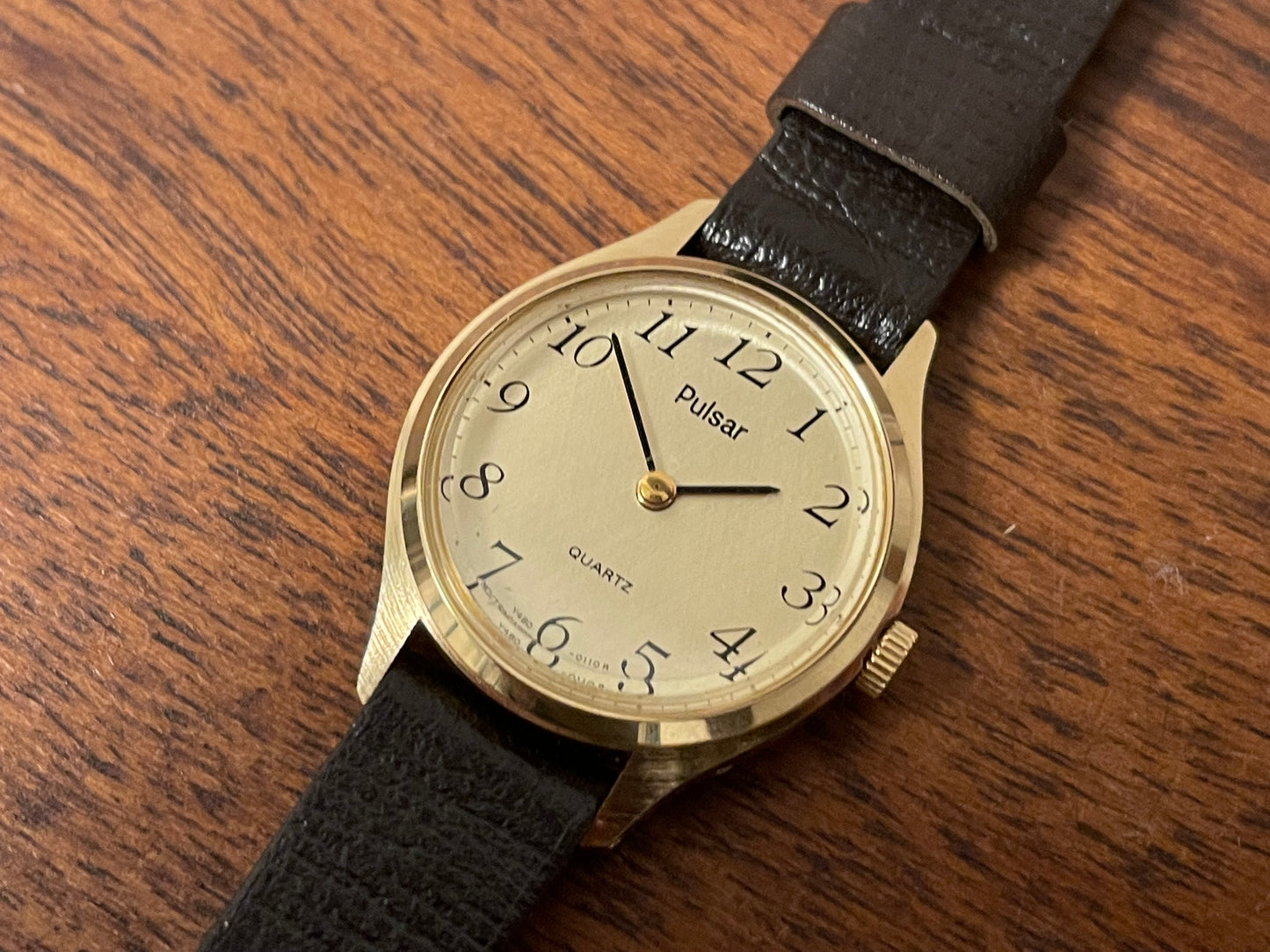 (1990) Pulsar Y480-0060 dress watch - gold colored case - champagne dial w/ black Arabic numerals - small size (NOS)