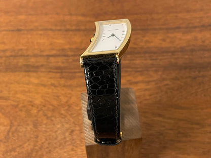 (1988) Cleto Munari "Parentesi" by Hans Hollein - asymmetrical 18K gold electroplated case - white dial w/ Roman numerals  (NOS + full set)