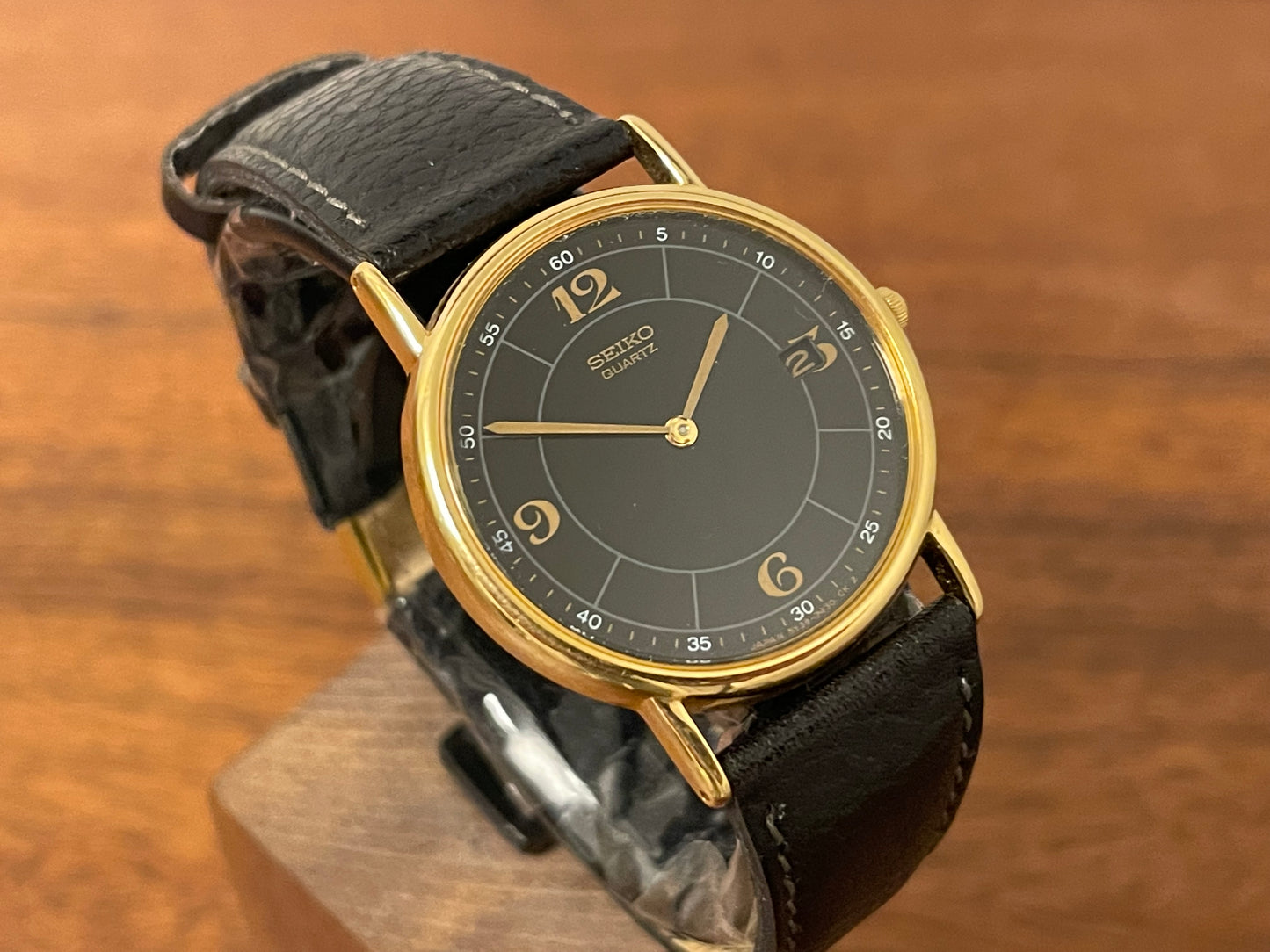 (2000) Seiko 5Y39-7010 dress watch - gold colored case - black dial w/ flat gold Arabic numerals (NOS)