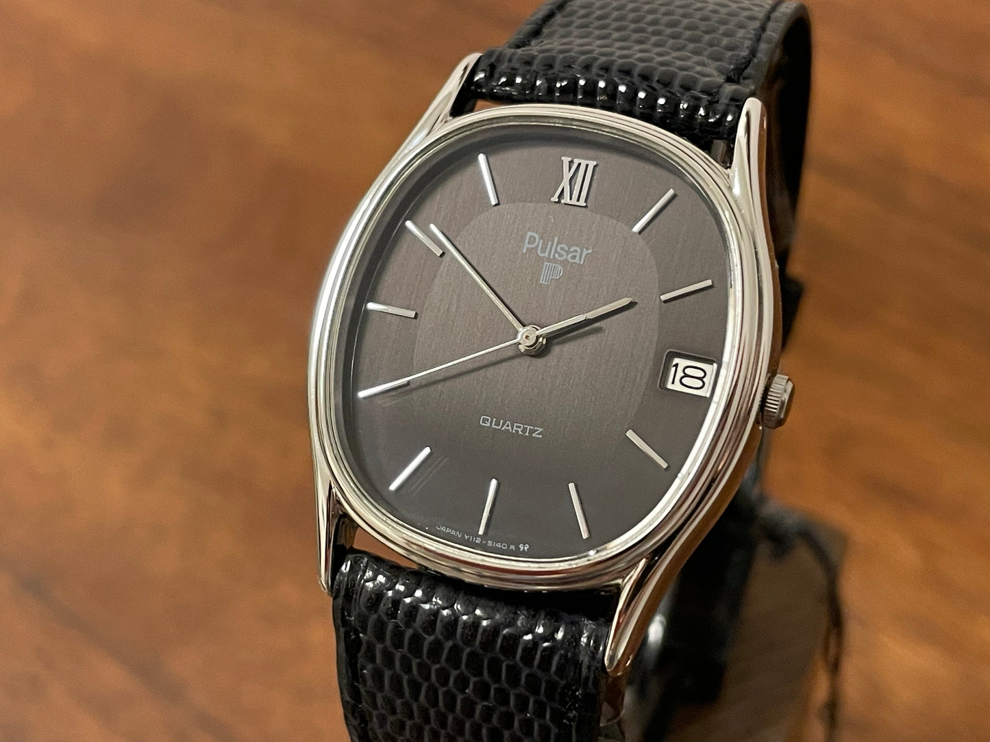 (1982) Pulsar Y112-5099 "Ellipse" dress watch - silver case - black dial w/ silver stick markers (NOS)