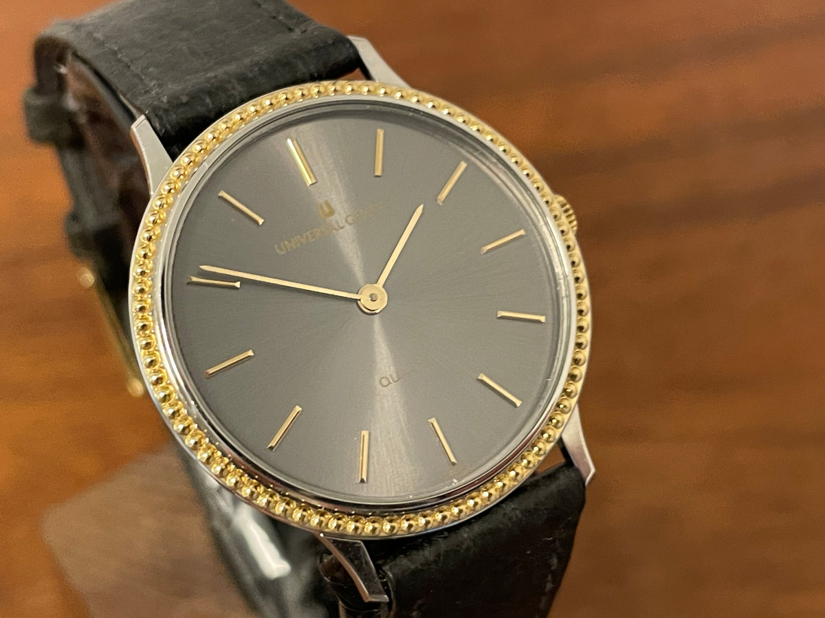 (1980s) Universal Genève 6-566 dress watch - silver case w/ gold beaded bezel - grey sunburst dial (NOS)