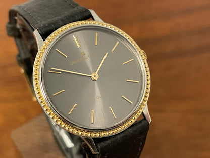 (1980s) Universal Genève 6-566 dress watch - silver case w/ gold beaded bezel - grey sunburst dial (NOS)