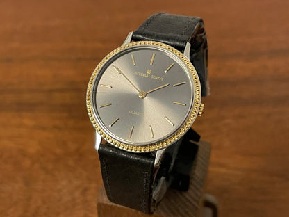 Front side (1980s) Universal Genève 6-566 dress watch - silver case w/ gold beaded bezel - grey sunburst dial (NOS)