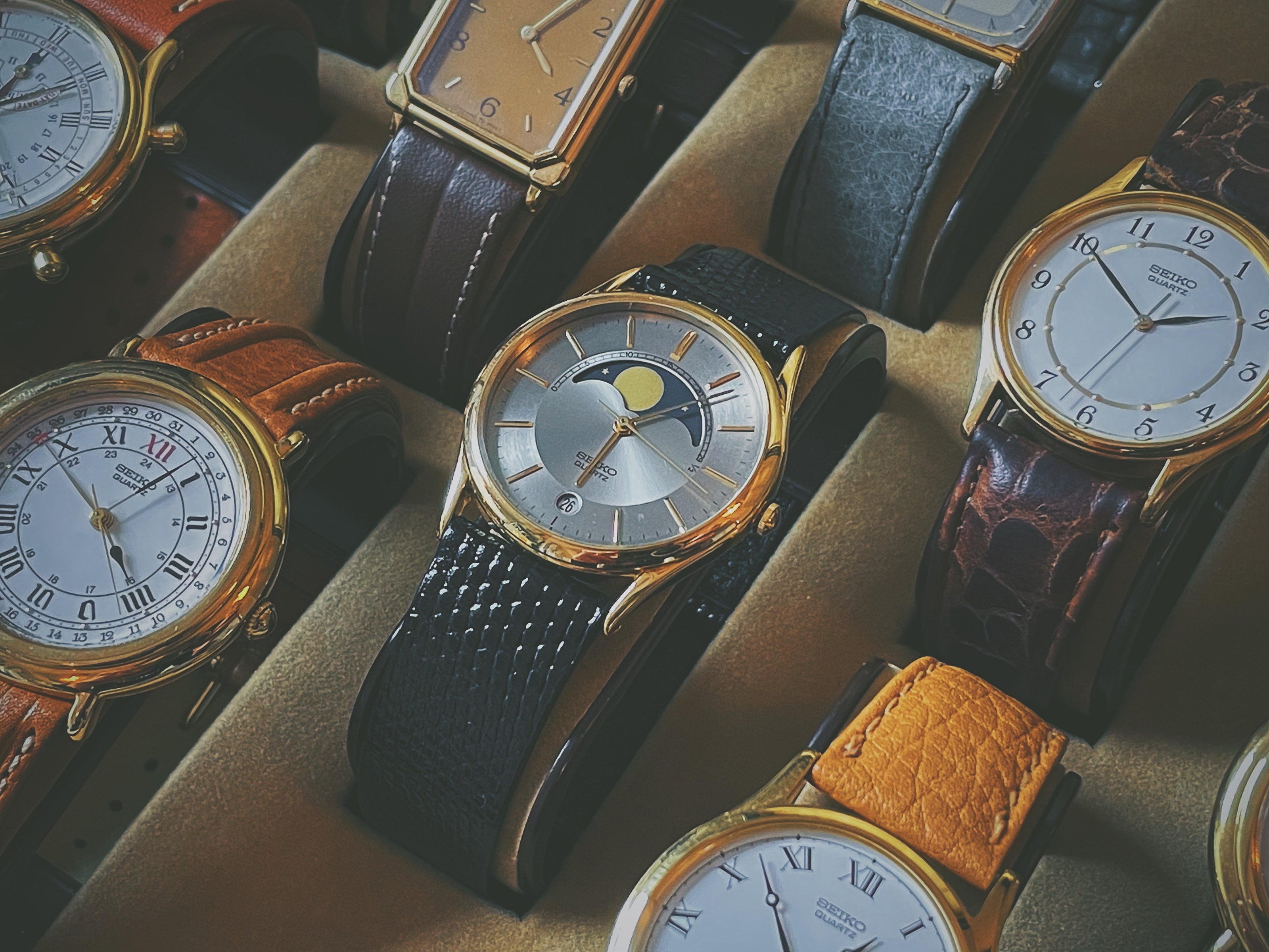 Seiko 7434-7000 dress watch with moon phase in showcase next to other Seiko dress watches