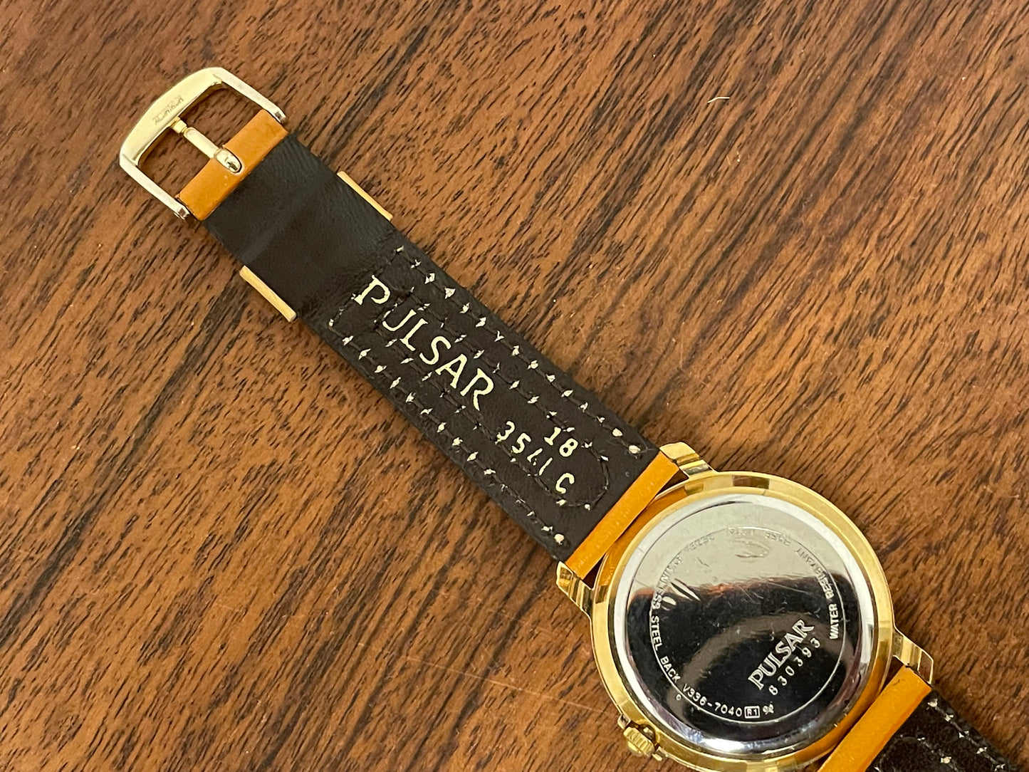 (1988) Pulsar V336-7040 dress watch - gold colored case - creme dial w/ Arabic numerals