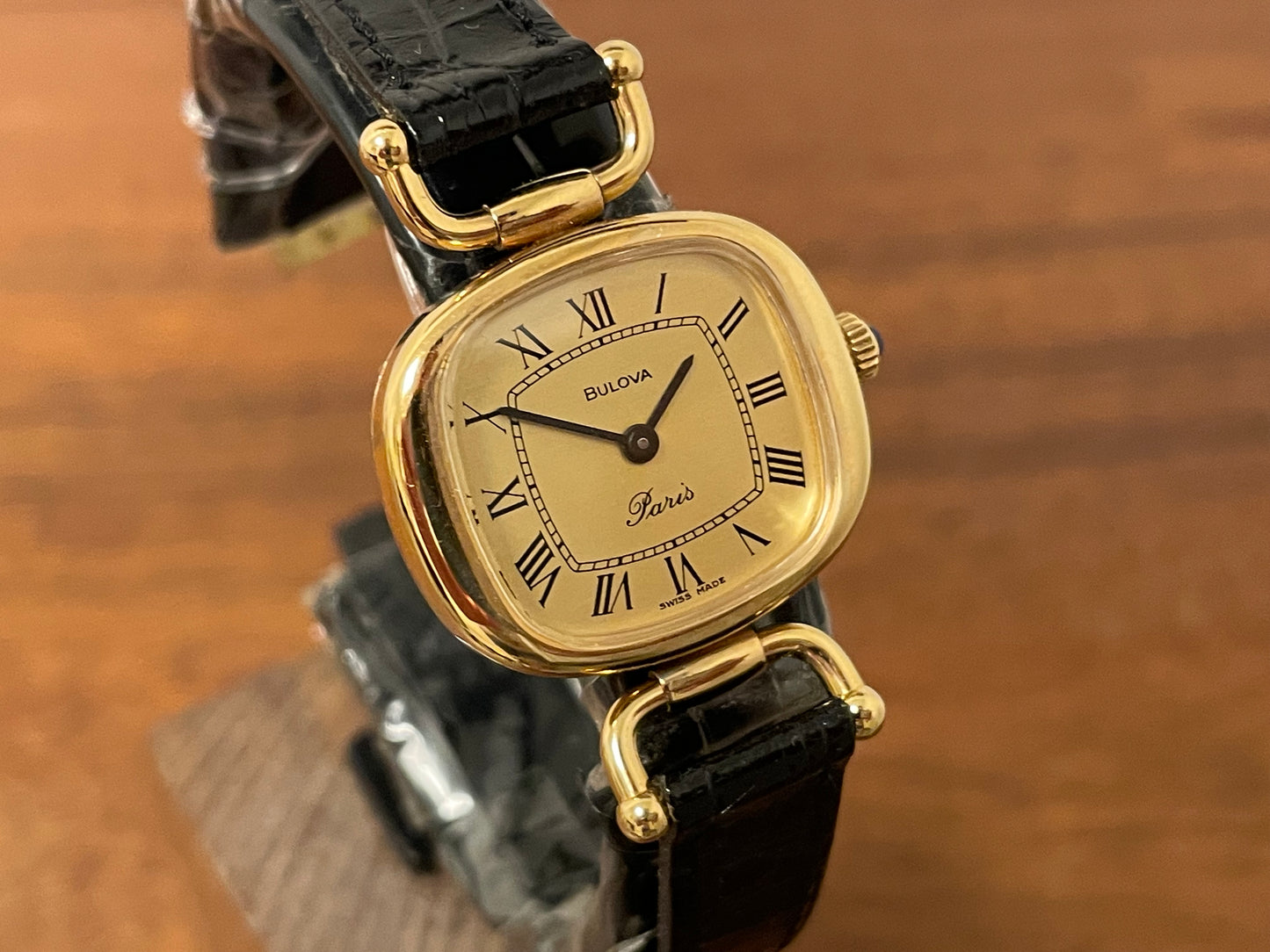 (1980s/1990s) Bulova Paris dress watch - cushion case - gold dial w/ black Roman numerals - small size (NOS)