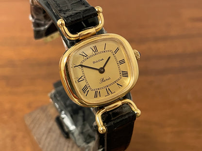 (1980s/1990s) Bulova Paris dress watch - cushion case - gold dial w/ black Roman numerals - small size (NOS)