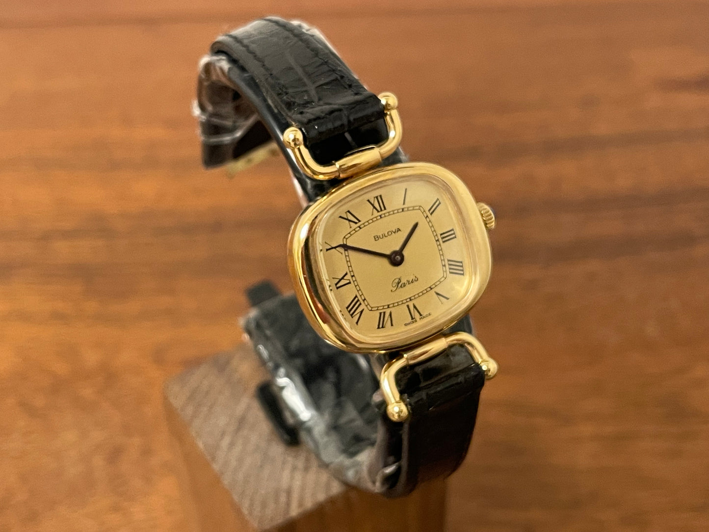 (1980s/1990s) Bulova Paris dress watch - cushion case - gold dial w/ black Roman numerals - small size (NOS)