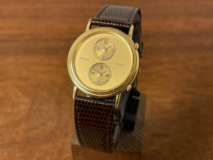 Front side (1985) Seiko 1E20-0160 dual time dress watch - round case - gold textured dial w/ 2 subdials