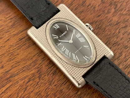 (1970s) Tissot Stylist "Tank" - decorated case - black sunburst dial w/ white Roman numerals - small size (NOS)