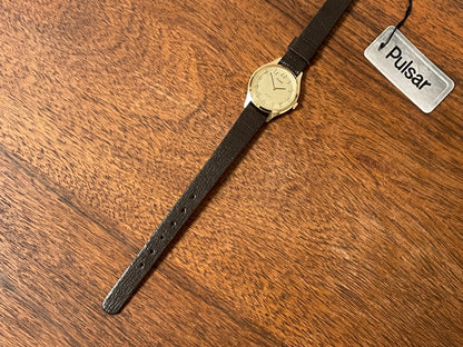 (1990) Pulsar Y480-0060 dress watch - gold colored case - champagne dial w/ black Arabic numerals - small size (NOS)