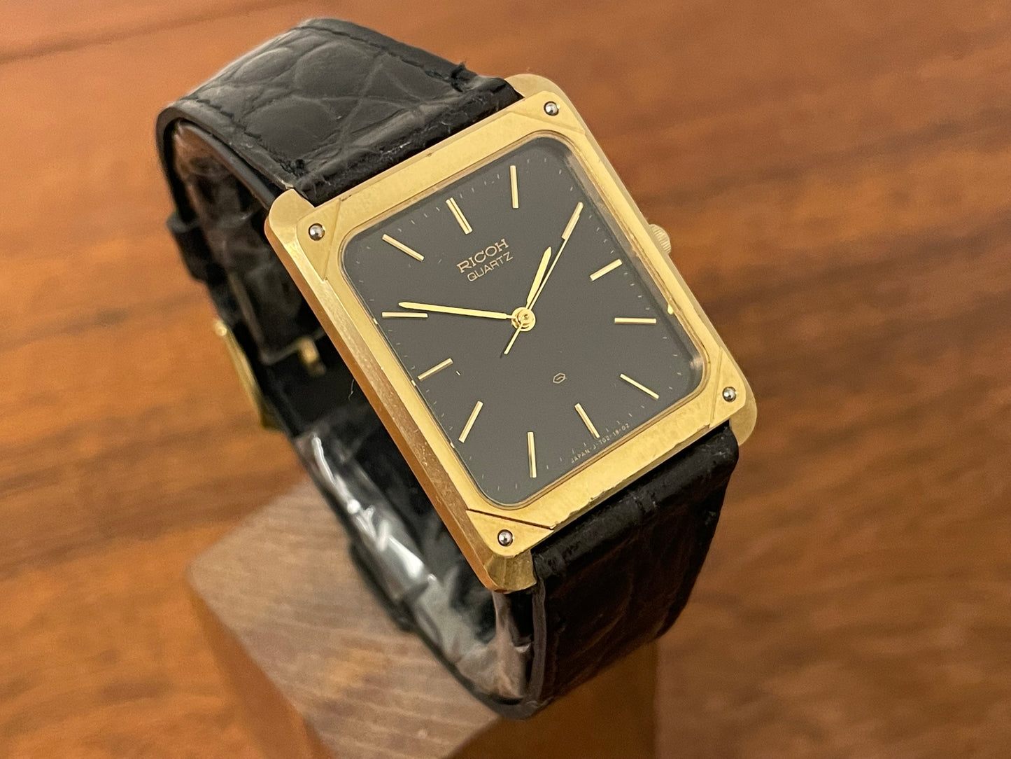 (1977) Ricoh 702009 quartz "Tank" dress watch - black dial w/ gold markers (NOS)