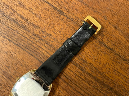 (1970s) Tissot Stylist dress watch - gold case - black dial w/ gold Roman numerals (NOS)