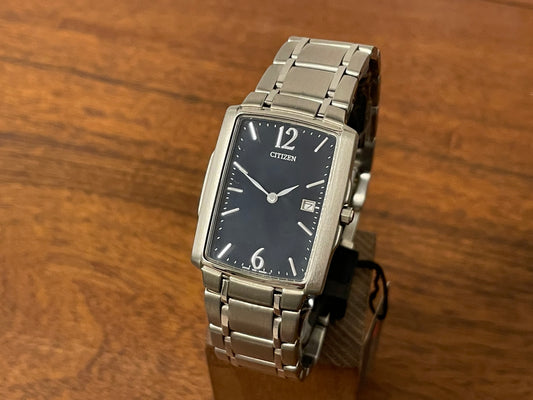 Front side (1990) Citizen 1015-H23389 - integrated bracelet - black dial w/ silver Arabic numerals & markers (NOS)