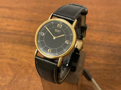 Front side (2000) Seiko 5Y39-7010 dress watch - gold colored case - black dial w/ flat gold Arabic numerals (NOS)