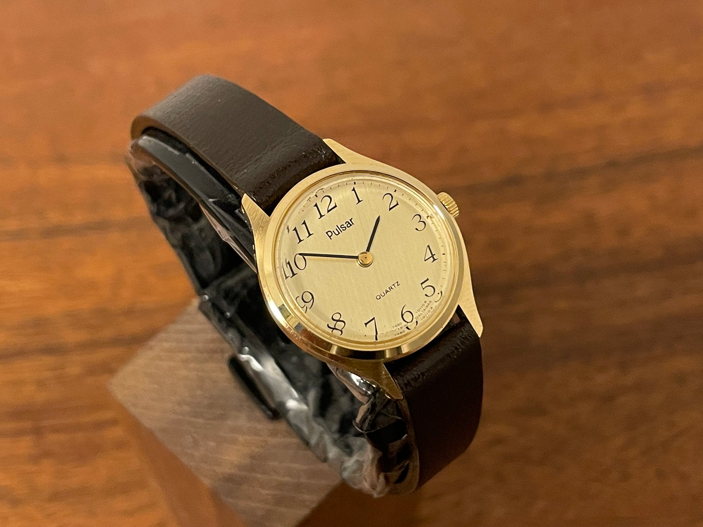 (1990) Pulsar Y480-0060 dress watch - gold colored case - champagne dial w/ black Arabic numerals - small size (NOS)