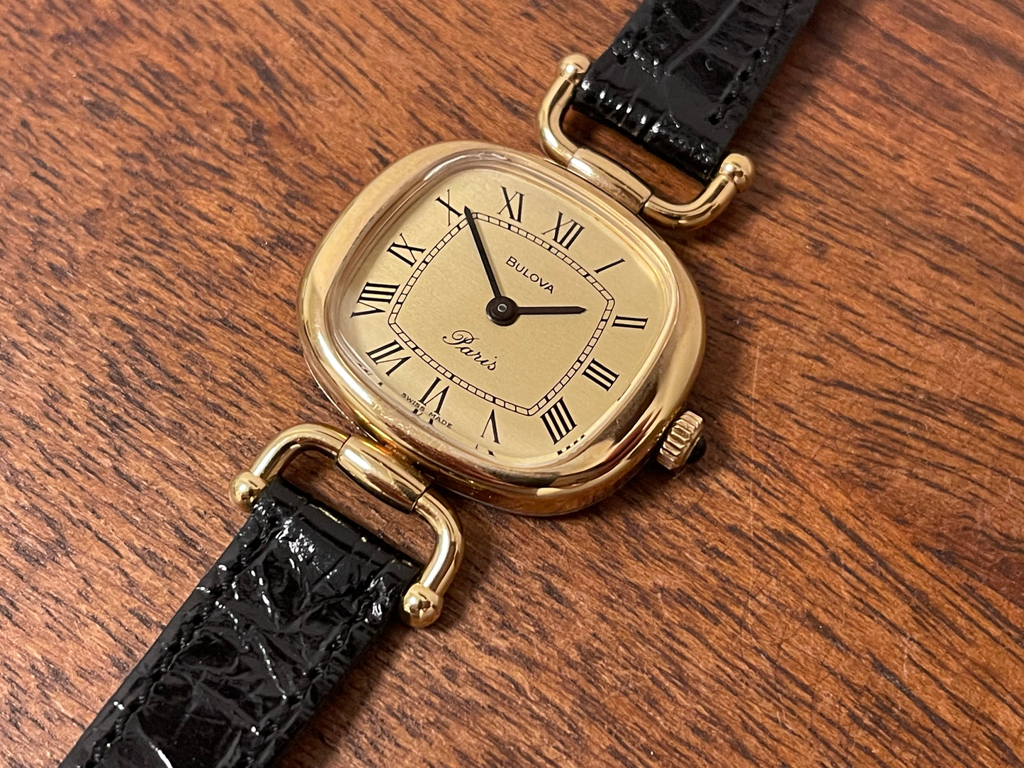 (1980s/1990s) Bulova Paris dress watch - cushion case - gold dial w/ black Roman numerals - small size (NOS)