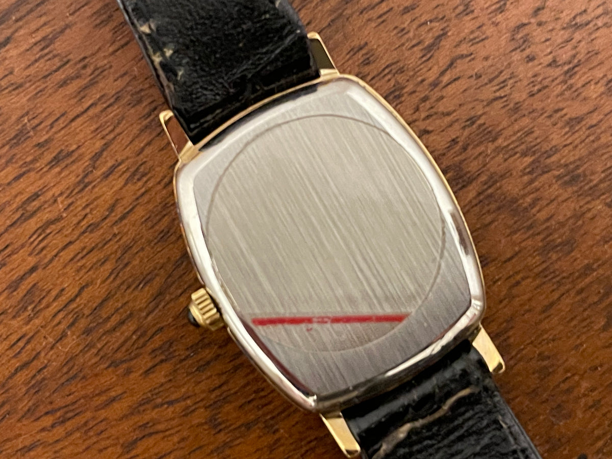 (1980s) Tissot 642.33500/5 Stylist "Ellipse" dress watch - gold case - black dial w/ Roman numerals - small size (NOS)