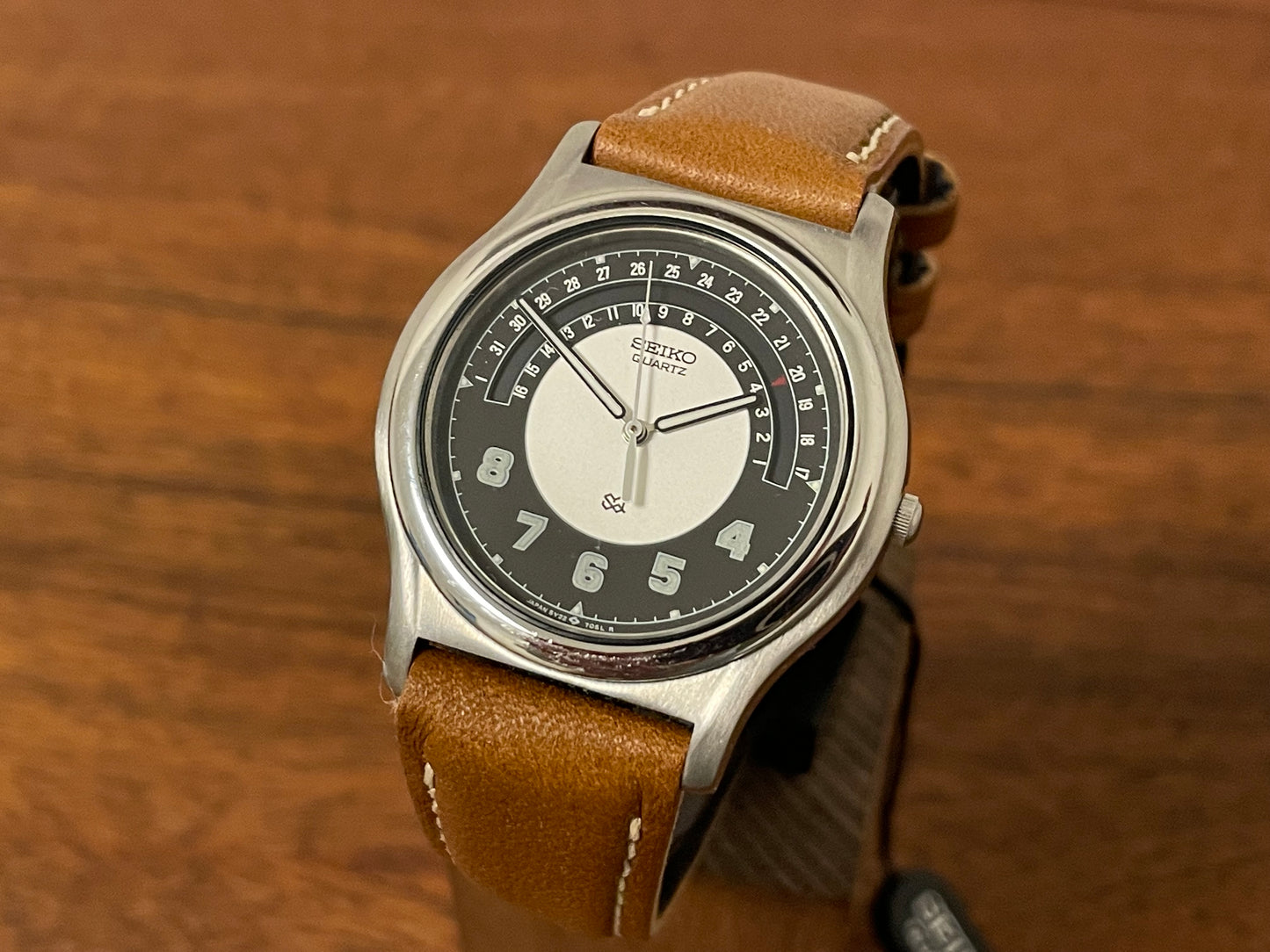 Front side (1988) Seiko 5Y22-7010 Quartz SQ dress watch - black dial w/ 180° arc date window (NOS)