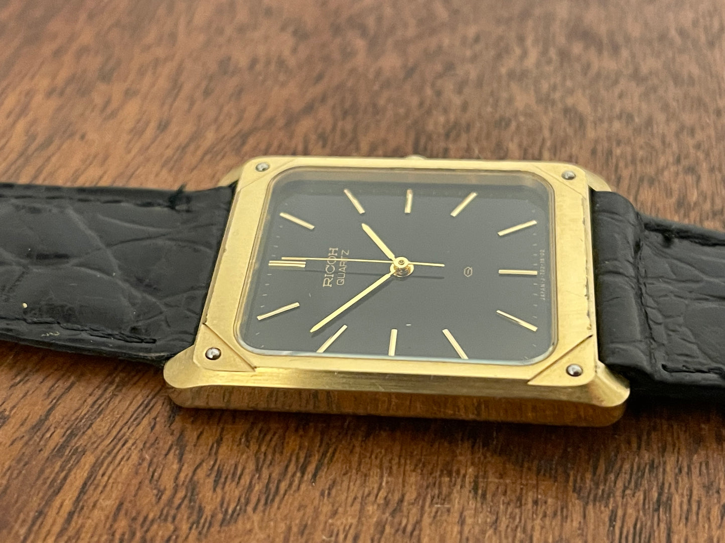 (1977) Ricoh 702009 quartz "Tank" dress watch - black dial w/ gold markers (NOS)