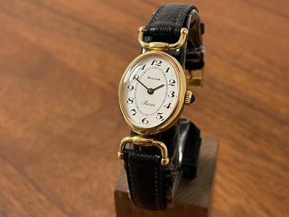 Front side (1980s/1990s) Bulova Paris dress watch - oval case - cream dial w/ black Arabic numerals - small size (NOS)