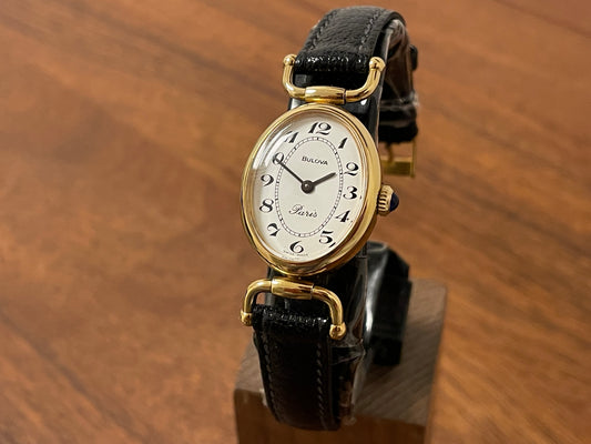 Front side (1980s/1990s) Bulova Paris dress watch - oval case - cream dial w/ black Arabic numerals - small size (NOS)