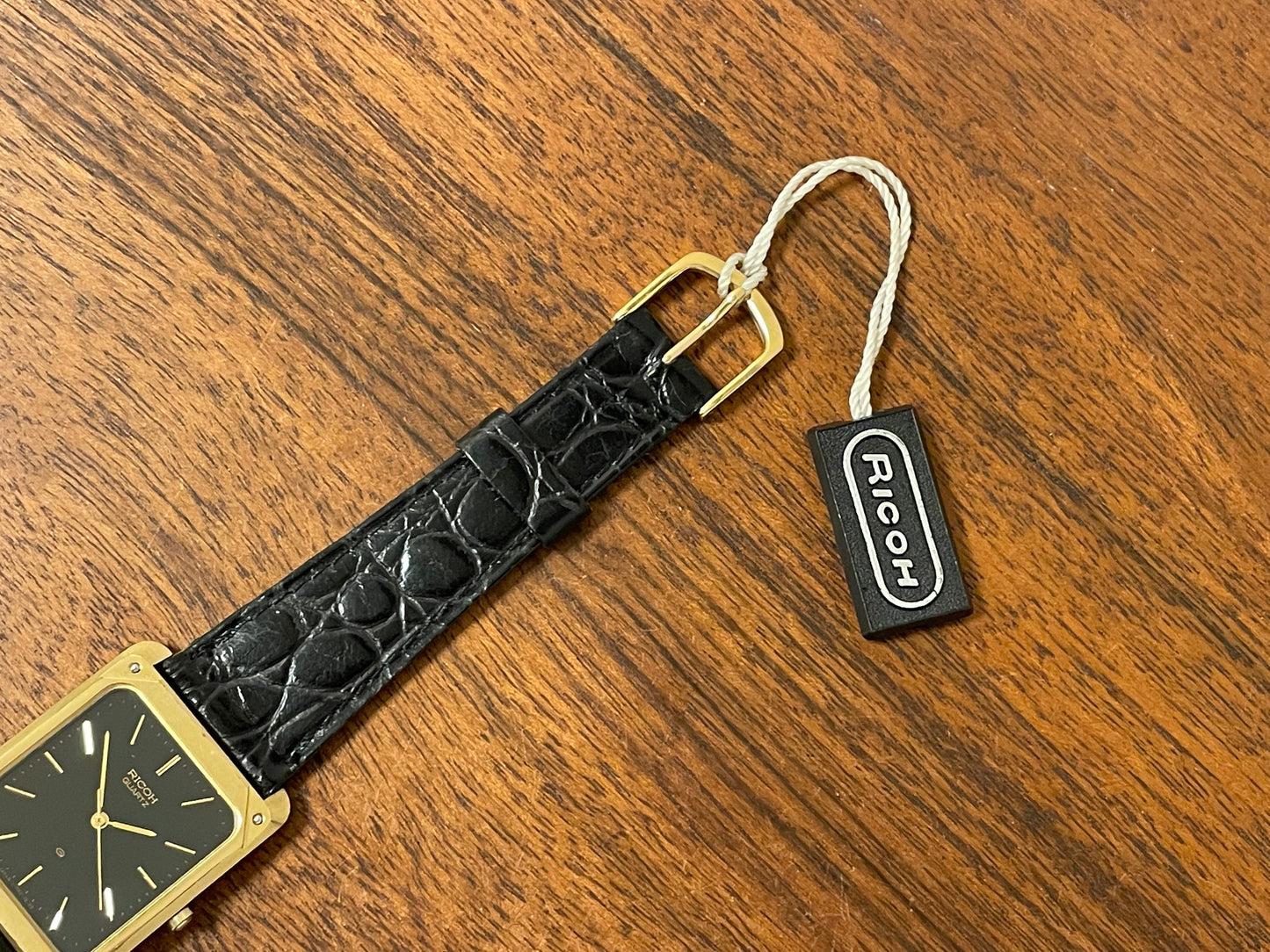 (1977) Ricoh 702009 quartz "Tank" dress watch - black dial w/ gold markers (NOS)