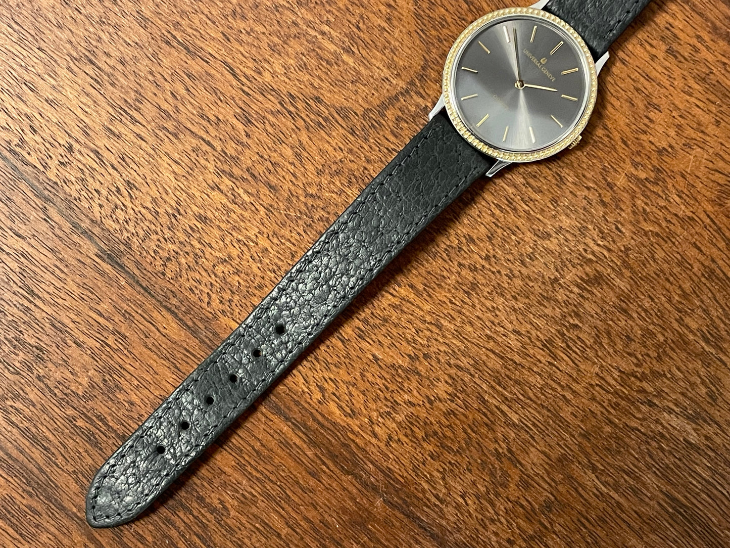 (1980s) Universal Genève 6-566 dress watch - silver case w/ gold beaded bezel - grey sunburst dial (NOS)
