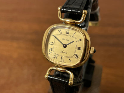 (1980s/1990s) Bulova Paris dress watch - cushion case - gold dial w/ black Roman numerals - small size (NOS)