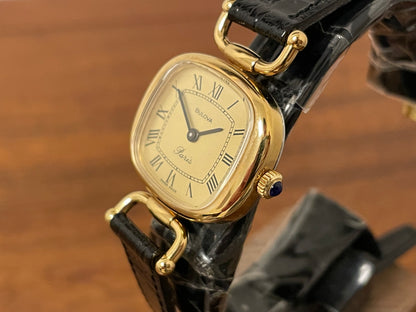 (1980s/1990s) Bulova Paris dress watch - cushion case - gold dial w/ black Roman numerals - small size (NOS)