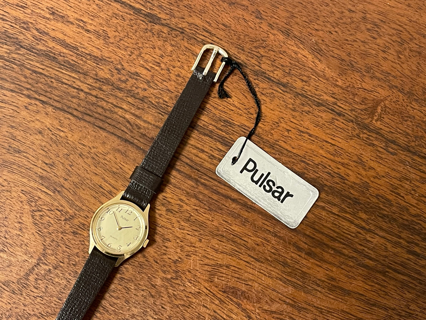 (1990) Pulsar Y480-0060 dress watch - gold colored case - champagne dial w/ black Arabic numerals - small size (NOS)