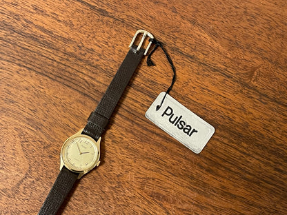 (1990) Pulsar Y480-0060 dress watch - gold colored case - champagne dial w/ black Arabic numerals - small size (NOS)