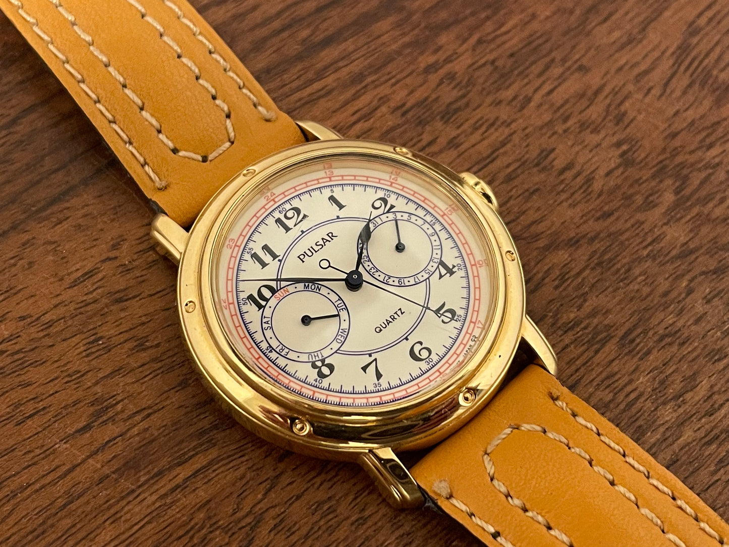 (1988) Pulsar V336-7040 dress watch - gold colored case - creme dial w/ Arabic numerals