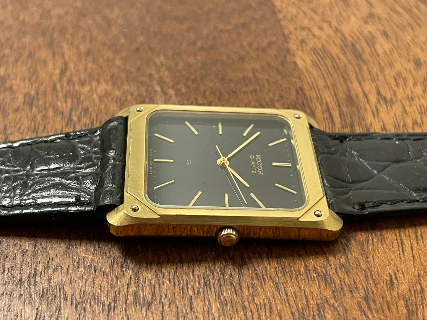 (1977) Ricoh 702009 quartz "Tank" dress watch - black dial w/ gold markers (NOS)