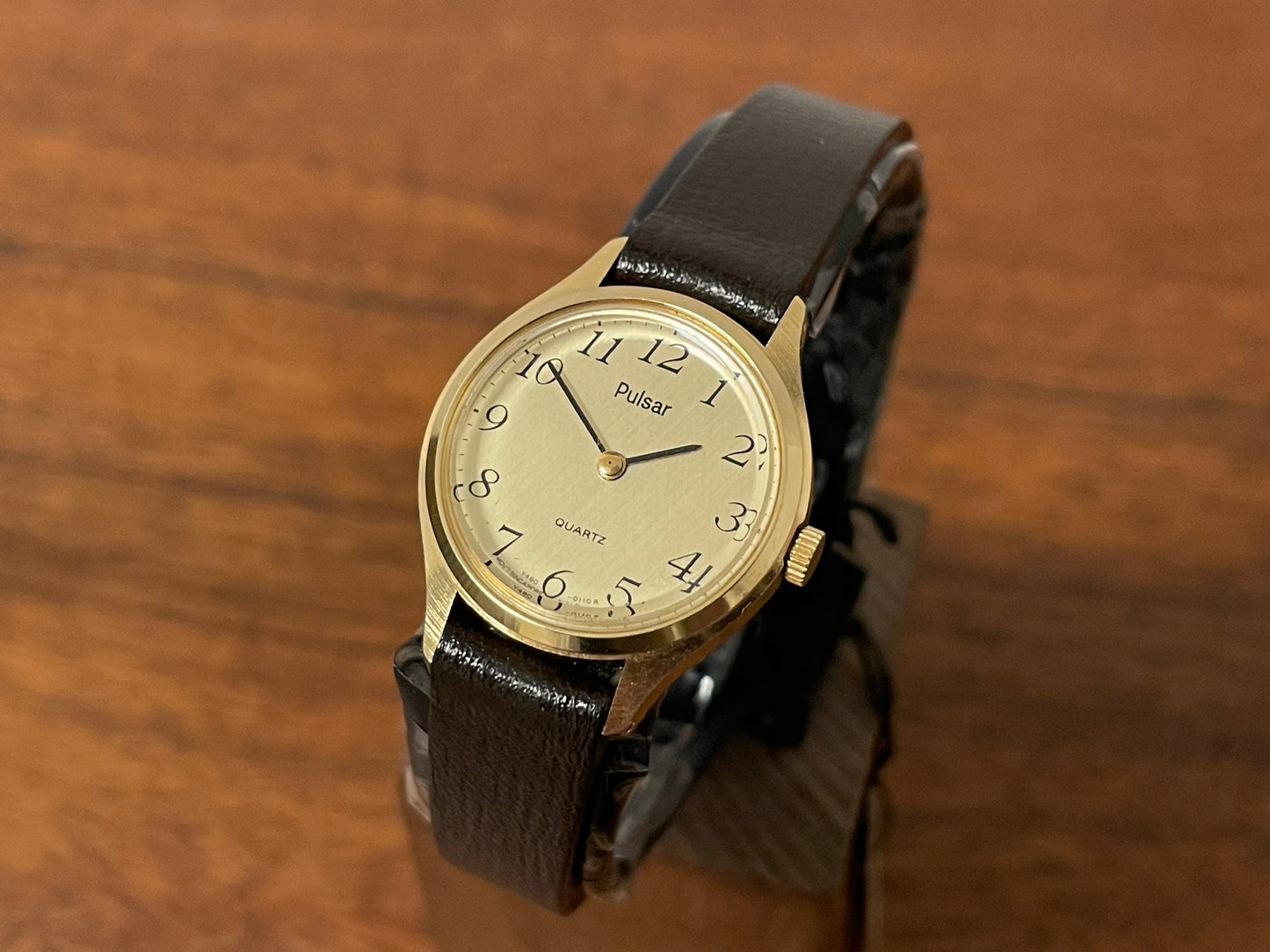 Front side (1990) Pulsar Y480-0060 dress watch - gold colored case - champagne dial w/ black Arabic numerals - small size (NOS)